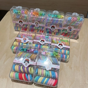 Colorful elastic hair bands and mini clips set in a transparent storage box