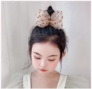 Dettaglio del fermaglio per capelli per bambina con fiocco in tulle beige a pois
