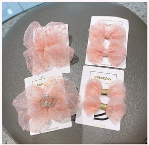 Dettaglio di fermagli per capelli in tulle rosa ed elastico con corona di strass su cartoncino