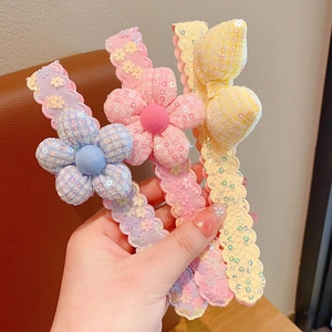 Vue détaillée des barrettes à fleurs et nœuds en paillettes pour filles et enfants