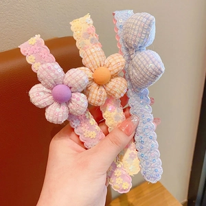 Détail de trois jolies barrettes de dessin animé avec fleurs et paillettes brillantes