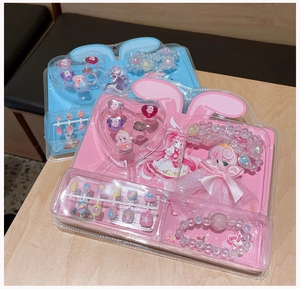 Close-up of kids' cartoon nail sticker set with pink beaded bracelet and cute rings