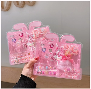 Close-up of kids' pink jewelry gift set including rings, bracelet and cartoon nail stickers