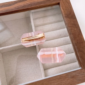 Pink geometric checkered hair clips set in a wooden jewelry box for styling