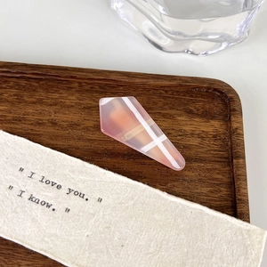 Macro shot of pink translucent acrylic duckbill hair clip with white geometric patterns