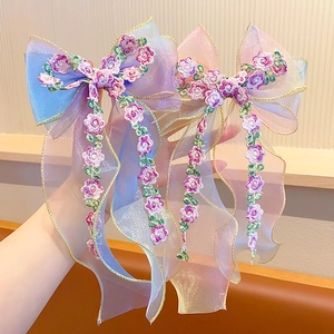 Close-up of embroidered mesh bow hair clips with long tassels and gradient tulle fabric