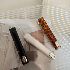 Three acetate hair clips in leopard, cream and black finish on a stylish tray