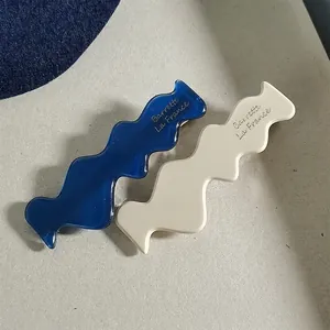 Blue and white wave-shaped acetate hair clips with French minimalist barrette style