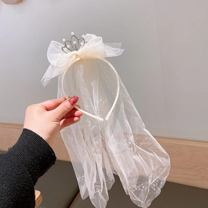 Detail of princess hair hoop with tulle bow, pearl crown and sequined long veil