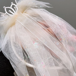 Detail of children's princess tiara headband with sparkly star sequins and layered white tulle
