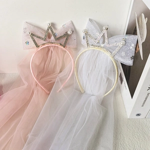 Detail of pink and white crown headbands with pearl accents and long flowing veils