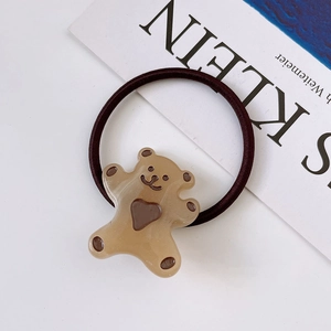 Detailed view of a brown elastic hair tie with a cute resin bear and heart design