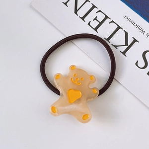 Detail of cute bear charm on elastic hair tie with yellow heart and paw prints