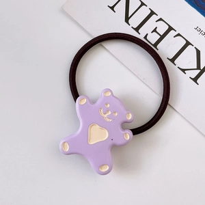 Detailed view of a purple resin cartoon bear hair tie on a minimalist white background