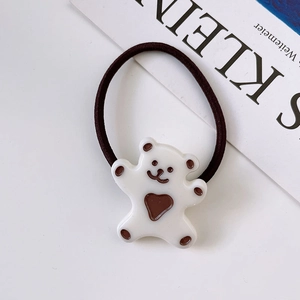 Detail view of a white cartoon bear charm on high-elastic dark brown hair band for girls
