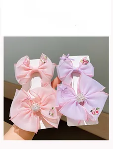 Detail of four-piece set with embroidered organza flower bows and crystal accents