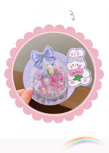 Detailed view of kids' press-on nail set featuring cute pink rabbit and rainbow patterns