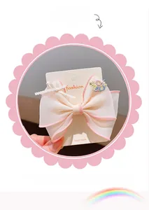 Detail of pink organza hair bow with embroidered flowers and non-slip metal clip
