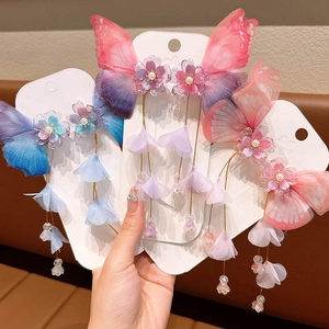 Detailed view of handmade butterfly tassel hair clips with pearls and silk petals