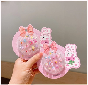 Detailed view of pink cartoon nail stickers featuring rainbow, butterfly, and cherry patterns