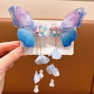 Detail of butterfly hair clip with resin wings, pearl flowers and gold tassel fringe