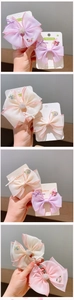 Detail of handmade floral embroidery and pearl accents on elegant tulle bow clips