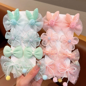 Détails des barrettes à cheveux avec nœuds en tulle, paillettes et pompons de perles