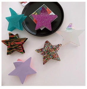 Flat lay of star-shaped hair claws in assorted colors and glitter acrylic textures
