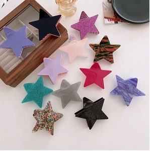 Macro shot showing diverse colors and textures of large star-shaped hair claw clips