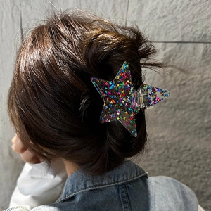 Star-shaped hair claw clip with colorful glitter sequins worn on long brown hair