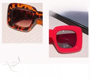 Detail view of square oversized sunglasses in leopard tortoise and bright red glossy finish