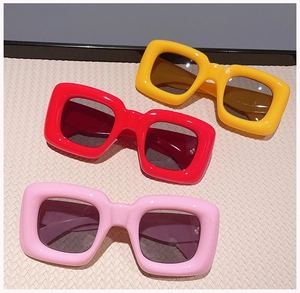 Three pairs of bold oversized square sunglasses in yellow, red, and light pink colors