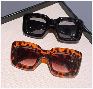 Macro view of thick square sunglasses in glossy black and classic tortoiseshell patterns