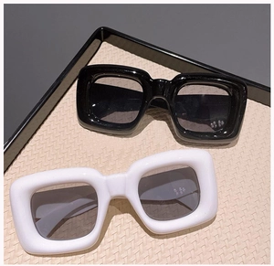 Detail view of thick square frame sunglasses in black and white colors on a tray