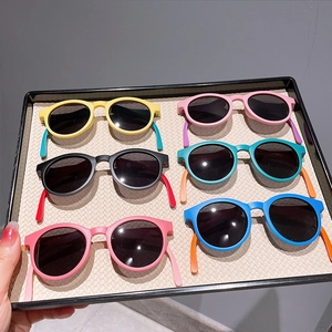 Selection of six colorful kids folding sunglasses arranged on a textured display tray