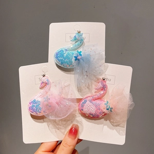 Trois pinces à cheveux cygne avec paillettes et nœuds en tulle en bleu, rose et rouge
