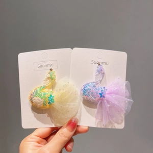 Détail de barrettes cygne mignonnes avec paillettes et ailes en tulle vaporeux