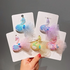 Détail de cinq barrettes cygne colorées avec ailes en tulle et couronnes pailletées