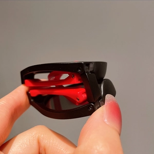Close-up of portable folding kids sunglasses featuring a classic red and black frame design