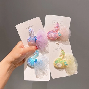 Détail des barrettes cygne avec paillettes et ailes en tulle en quatre couleurs pastel