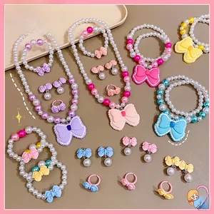 Vue détaillée d'ensembles de bijoux pour enfants avec perles macaron et nœuds papillon