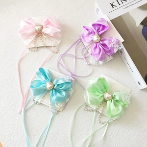 Detail view of lace bow hair clips with satin ribbons and pearl heart charms