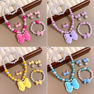 Parure de bijoux quatre pièces pour enfants avec perles et grands nœuds en résine