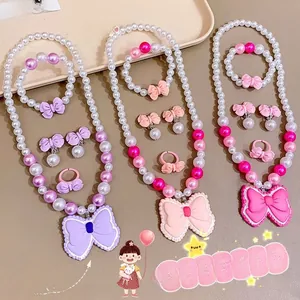 Détail d'un ensemble de bijoux pour enfants avec collier de perles et nœud violet
