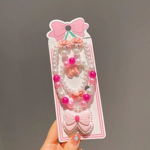 Détail de l'ensemble bijoux pour filles avec perles roses, nœud en dentelle et boucles à clips