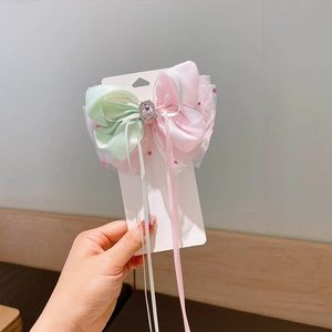 Detail of pink and mint layered bow hair clip with crystal center and long ribbons
