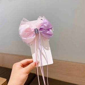 Detail of pink and purple gradient mesh bow hair clip with square crystal and silk ribbons