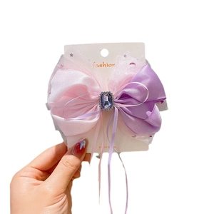 Pink and purple bow hair clip with star mesh, rhinestones and purple gem detail