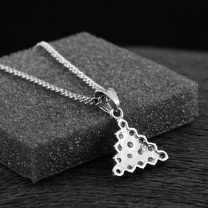 Détail du pendentif triangle argenté montrant les trous de sertissage et la chaîne polie