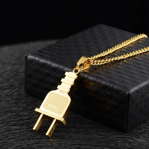 Macro d'un pendentif prise dorée avec gravure 8818 et I Love You sur boîte noire